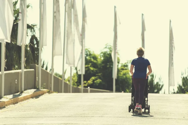 Młoda Matka Zdrowe Joggingu Podczas Pchania Wózka Dziecka Parku Miejskim — Zdjęcie stockowe