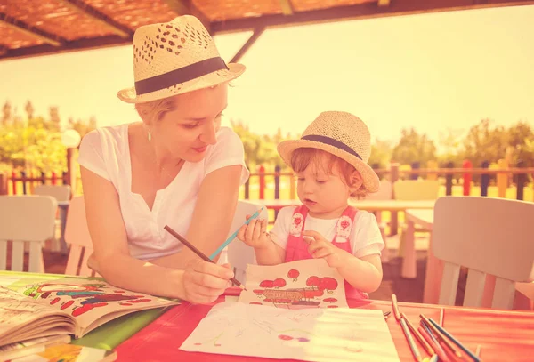 若い母親と彼女少し娘元気支出の時間外保育でカラフルな絵を描くときの鉛筆クレヨンを使って一緒に — ストック写真