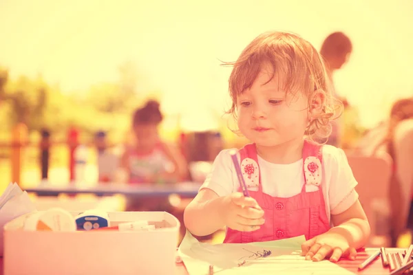 かわいい鉛筆を使用してほとんどの女の子元気過ごす時間は 外遊びの学校でカラフルな絵を描く中のクレヨンします — ストック写真