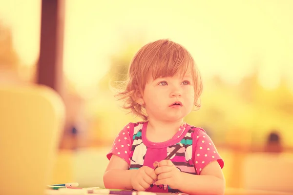 可爱的小女孩愉快地花时间使用铅笔蜡笔 而在外面的游戏学校画一个五颜六色的图片 — 图库照片