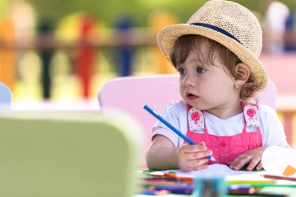 可爱的小女孩愉快地花时间使用铅笔蜡笔 而在外面的游戏学校画一个五颜六色的图片 — 图库照片