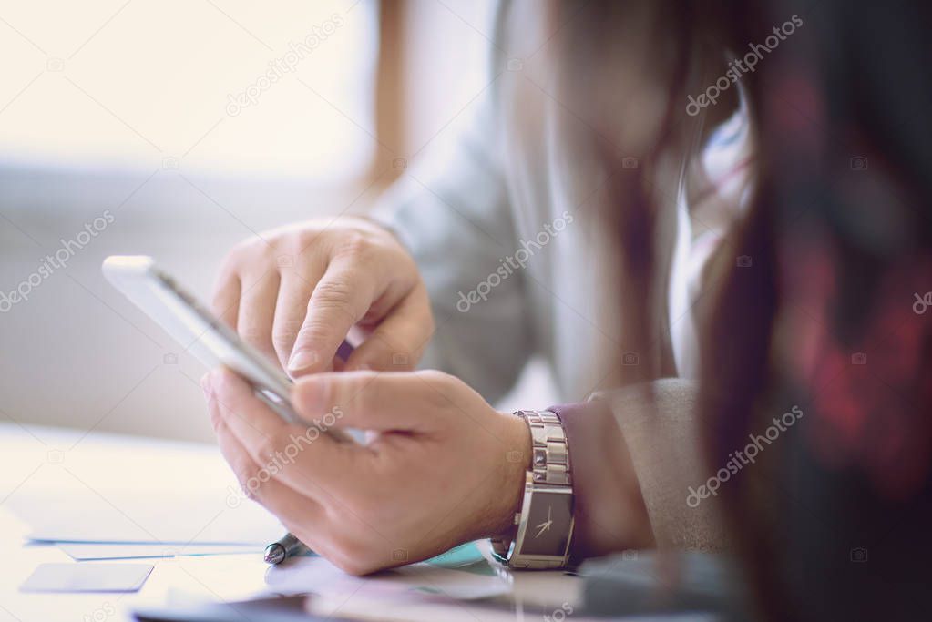 business people hands typing on smart phone during the seminar at conference room