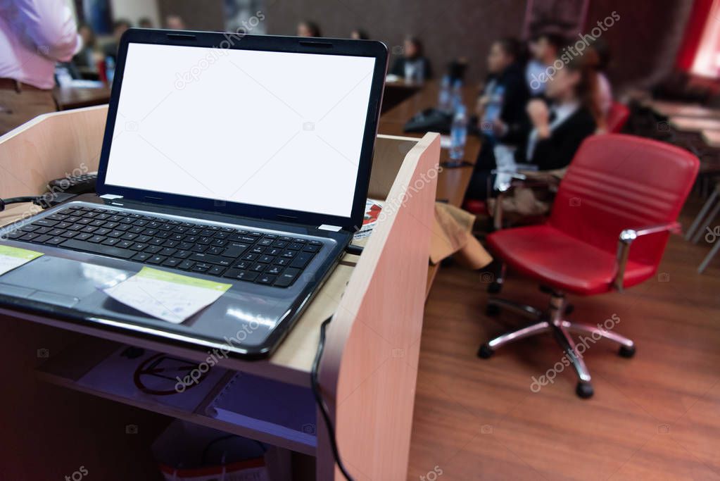 laptop computer at podium on business seminar education  in modern conference room