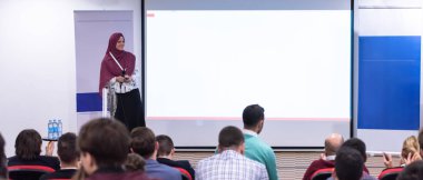 genç müslüman iş kadını iş konferans salonunda halka açık sunumlar yapıyor. Konferans salonundaki seyirciler. Girişimcilik Kulübü