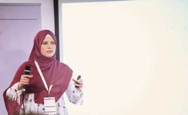 genç müslüman iş kadını iş konferans salonunda halka açık sunumlar yapıyor. Konferans salonundaki seyirciler. Girişimcilik Kulübü