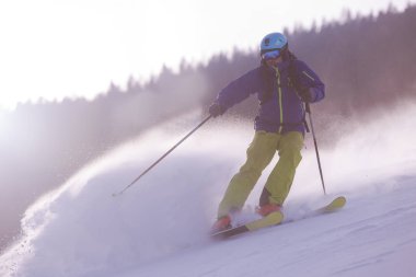 genç atlet freestyle kayakçı yokuş aşağı güneşli kış mevsiminde güzel alp manzara modunda çalışırken eğlenmek