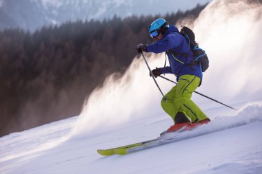 genç atlet freestyle kayakçı yokuş aşağı güneşli kış mevsiminde güzel alp manzara modunda çalışırken eğlenmek