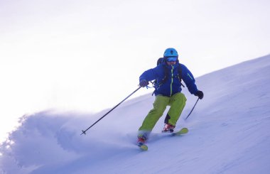 genç atlet freestyle kayakçı yokuş aşağı güneşli kış mevsiminde güzel alp manzara modunda çalışırken eğlenmek