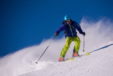 genç atlet freestyle kayakçı yokuş aşağı güneşli kış mevsiminde güzel alp manzara modunda çalışırken eğlenmek