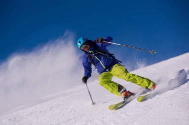 genç atlet freestyle kayakçı yokuş aşağı güneşli kış mevsiminde güzel alp manzara modunda çalışırken eğlenmek