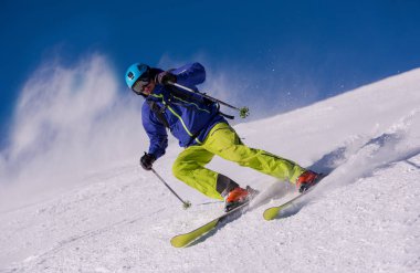 genç atlet freestyle kayakçı yokuş aşağı güneşli kış mevsiminde güzel alp manzara modunda çalışırken eğlenmek