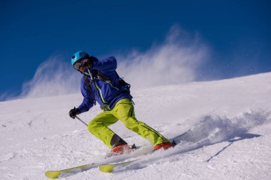 genç atlet freestyle kayakçı yokuş aşağı güneşli kış mevsiminde güzel alp manzara modunda çalışırken eğlenmek