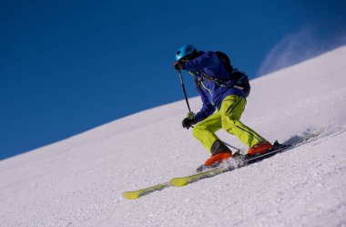 genç atlet freestyle kayakçı yokuş aşağı güneşli kış mevsiminde güzel alp manzara modunda çalışırken eğlenmek
