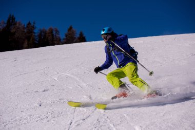 genç atlet freestyle kayakçı yokuş aşağı güneşli kış mevsiminde güzel alp manzara modunda çalışırken eğlenmek