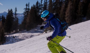 genç atlet freestyle kayakçı yokuş aşağı güneşli kış mevsiminde güzel alp manzara modunda çalışırken eğlenmek
