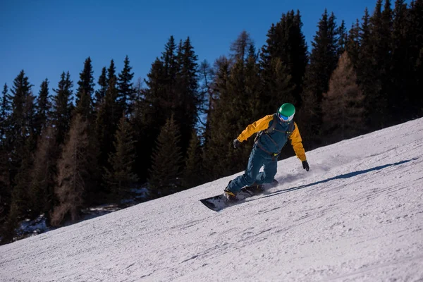 在高山阳光明媚的冬日 年轻的自由式滑雪者沿着山坡跑下 骑着自由的风格 冬季运动和娱乐 休闲户外活动 — 图库照片