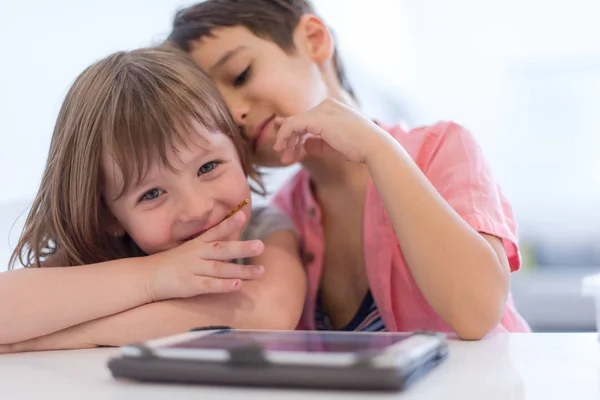 귀여운 동생과 여동생 재미를 집에서 태블릿 컴퓨터에 게임을 Childrends — 스톡 사진