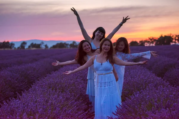 一群女性在美丽的日落薰衣草花田有乐趣 — 图库照片