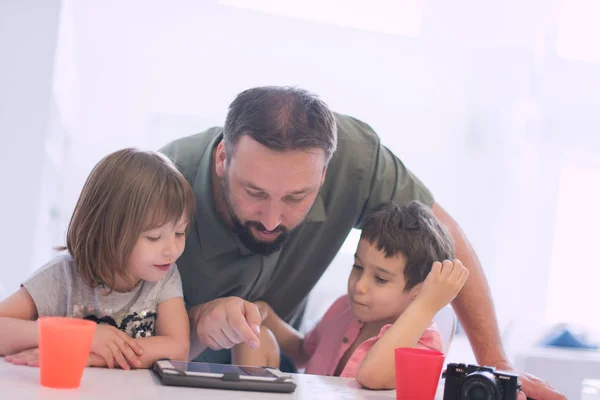 ゲームおよび現代家でタブレット コンピューターの教育のレッスンを与える 人の子供を持つ家庭で単一の父 — ストック写真