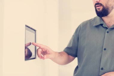 Akıllı ev ve teknoloji kavramı tablet pc bilgisayar entegre evde kapalı duvar'parmak işaret erkek elinde kapat