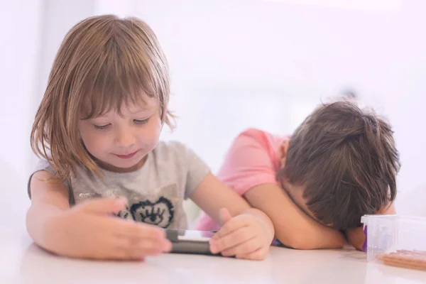 可爱的小弟弟和妹妹有乐趣在家里的孩子们在平板电脑上玩游戏 — 图库照片