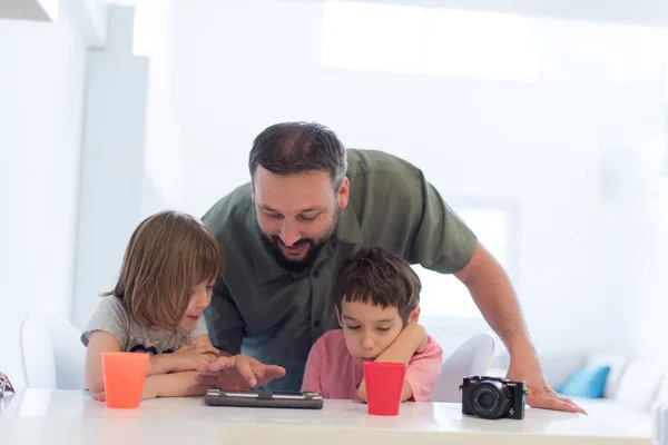 ゲームおよび現代家でタブレット コンピューターの教育のレッスンを与える 人の子供を持つ家庭で単一の父 — ストック写真