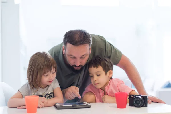 单身父亲在家 有两个孩子在现代家里玩游戏 在平板电脑上上教育课 — 图库照片