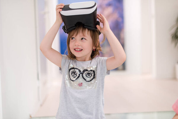маленький гирь дома в VR очках, поднимая руки вверх и играя в игры
