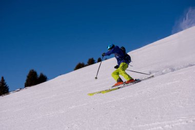 genç atlet freestyle kayakçı yokuş aşağı güneşli kış mevsiminde güzel alp manzara modunda çalışırken eğlenmek