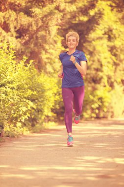 Genç sportif kadın atlet güzel tropikal Park'ta güneşli sabah çalışan maratonu için eğitim