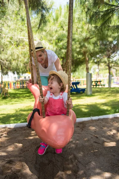 Junge Mutter Und Ihre Kleine Tochter Lächeln Zusammen Beim Schaukeln — Stockfoto