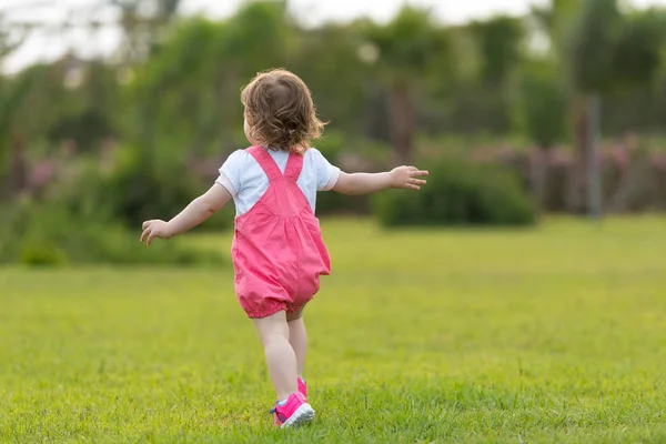 好玩可爱的小女孩愉快地花费时间 而在宽敞的后院在草地上运行 — 图库照片