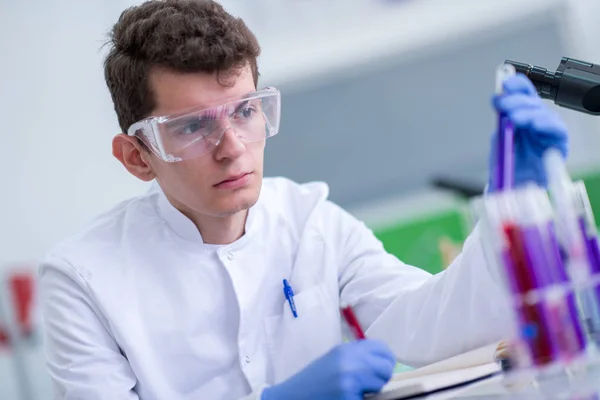 戴防护眼镜的年轻学生在明亮的实验室 教育和医学概念中进行化学实验 — 图库照片