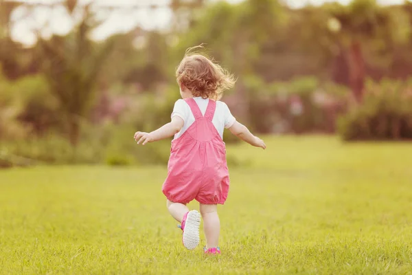 好玩可爱的小女孩愉快地花费时间 而在宽敞的后院在草地上运行 — 图库照片