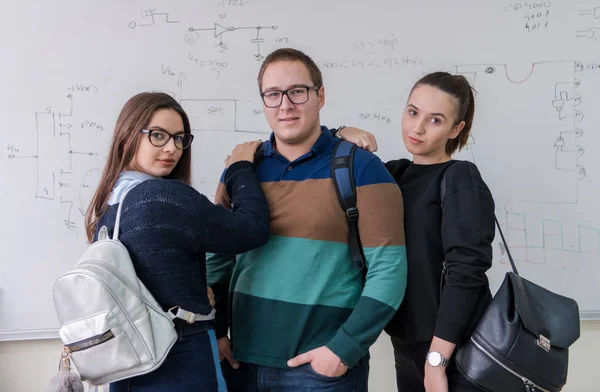 Retrato Grupo Jóvenes Estudiantes Pie Frente Pizarra Blanca Mirando Cámara —  Fotos de Stock