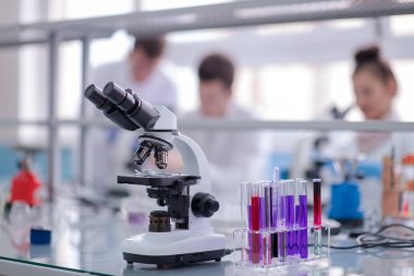 Çalışma yerindeki mikroskop farklı sıvıyla test tüplerinin yanında. Sağlık ve biyoteknoloji kavramı