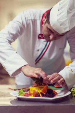 Şef lokanta mutfağında sebze salatası servis ediyor.