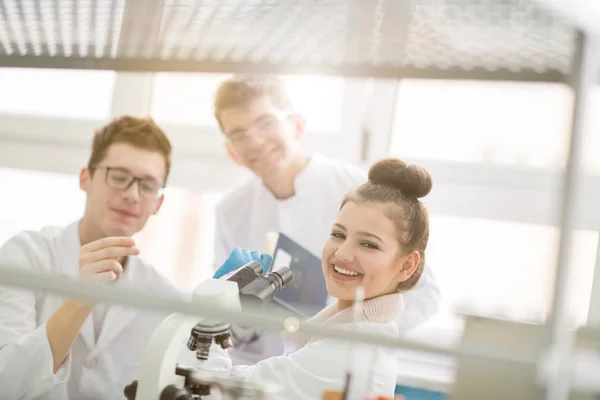 化学研究室で一緒に研究をしている若い医学生のグループ 室内で大学生によるチームワーク — ストック写真