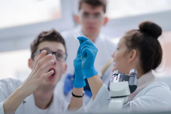 化学研究室で一緒に研究をしている若い医学生のグループ 室内で大学生によるチームワーク — ストック写真