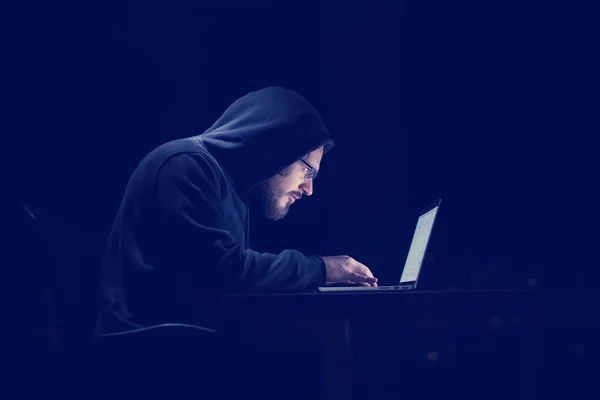 Młody Utalentowany Haker Przy Użyciu Laptopa Podczas Pracy Ciemnym Biurze — Zdjęcie stockowe