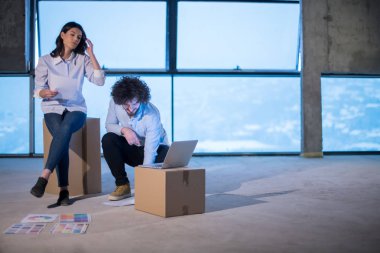 Gruptaki genç iş adamları, inşaat sahasındaki mimar ve mühendis yeni açılan ofiste dizüstü bilgisayar kullanarak belge ve iş akışını kontrol ediyorlar.