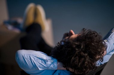 İnşaat alanındaki genç işadamı, yeni açılan ofisteki mukavva kutularla doküman ve iş akışını kontrol ederken ara veriyor.