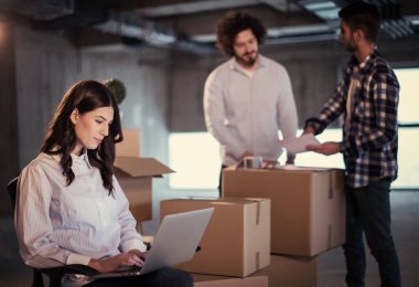 Gruptaki genç iş adamları, inşaat sahasındaki mimar ve mühendis yeni açılan ofiste dizüstü bilgisayar kullanarak belge ve iş akışını kontrol ediyorlar.