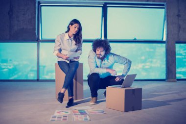 Gruptaki genç iş adamları, inşaat sahasındaki mimar ve mühendis yeni açılan ofiste dizüstü bilgisayar kullanarak belge ve iş akışını kontrol ediyorlar.