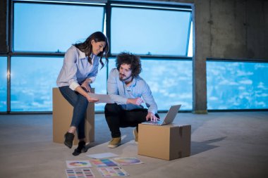 Gruptaki genç iş adamları, inşaat sahasındaki mimar ve mühendis yeni açılan ofiste dizüstü bilgisayar kullanarak belge ve iş akışını kontrol ediyorlar.