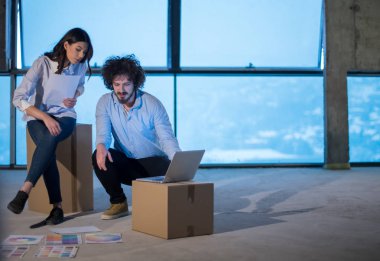 Gruptaki genç iş adamları, inşaat sahasındaki mimar ve mühendis yeni açılan ofiste dizüstü bilgisayar kullanarak belge ve iş akışını kontrol ediyorlar.