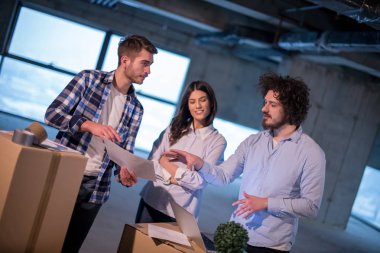Gruptaki genç iş adamları, inşaat sahasındaki mimar ve mühendis yeni açılan ofiste dizüstü bilgisayar kullanarak belge ve iş akışını kontrol ediyorlar.