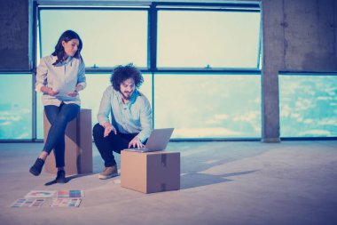 Gruptaki genç iş adamları, inşaat sahasındaki mimar ve mühendis yeni açılan ofiste dizüstü bilgisayar kullanarak belge ve iş akışını kontrol ediyorlar.