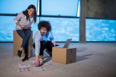 Gruptaki genç iş adamları, inşaat sahasındaki mimar ve mühendis yeni açılan ofiste dizüstü bilgisayar kullanarak belge ve iş akışını kontrol ediyorlar.