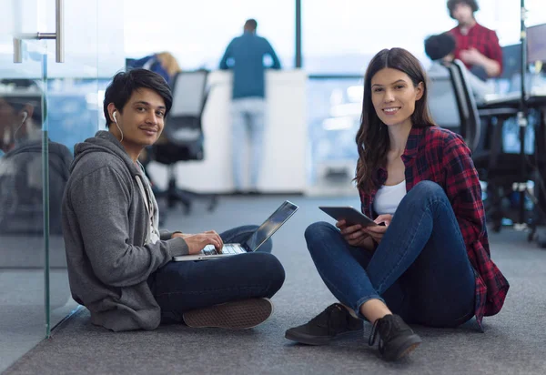 Jovens desenvolvedores de software casal trabalhando no chão — Fotografia de Stock